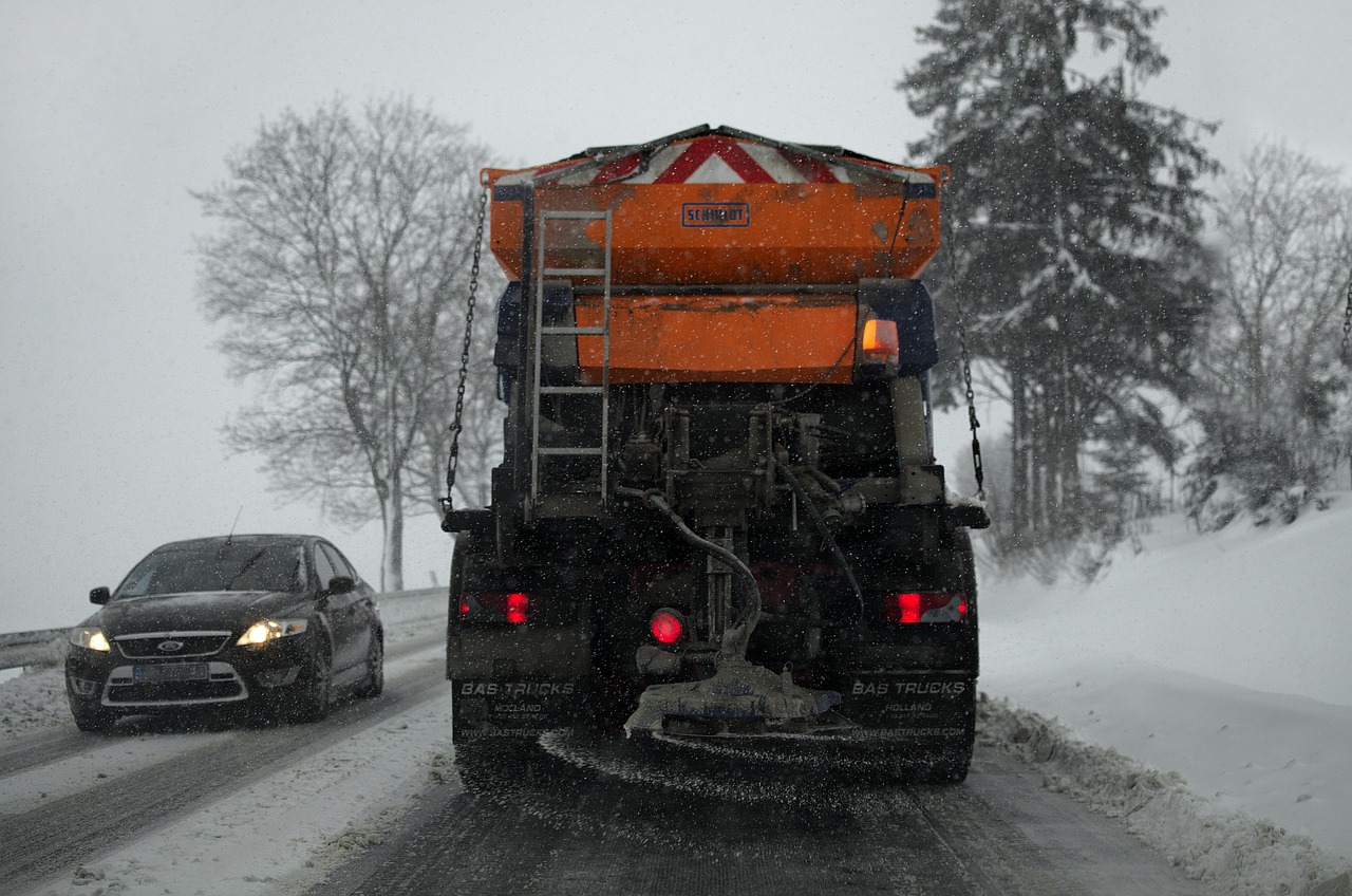 凍結防止剤(融雪剤)が撒かれた雪道を走行する車、下回りの錆の原因になる